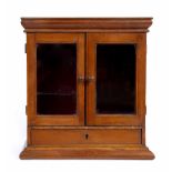 A STAINED PINE MINIATURE TABLE TOP CABINET fitted with frieze drawer and contents therein
