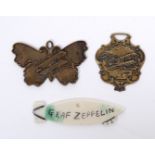 TWO KEY FOBS or badges depicting vintage bi planes together with a further key fob scratched with