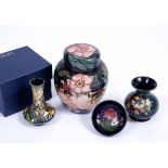 AN OLD MOORCROFT BOTTLE VASE 9.5cm high together with a pin dish, a further bottle vase and a jar