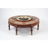 A Middle-Eastern laurel wood low dining table circular top on seven legs, with central cut out and