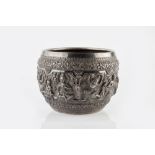A Burmese silver Thabeik bowl of traditional design, decorated in high relief with scrolling foliate