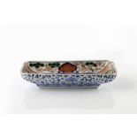 A Japanese Arita rectangular dish 19th Century with blue central panel and polychrome panel borders,