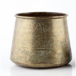 An Islamic brass bowl 19th century of tapering form, inscribed with scripture and geometric banded