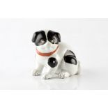 A Japanese porcelain model of a puppy circa 1900 with red ribbon collar, 12cm across