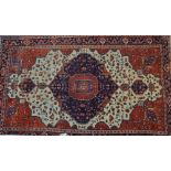 A Sarouk Rug of red and white ground, displaying a central panel as a leaf, with a border displaying