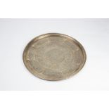 A Middle Eastern brass tray 19th Century engraved with boarders of Islamic text and geometric