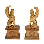 A PAIR OF EGYPTIAN REVIVAL GILT BRONZE SPHINXS each seated on a plinth with laurel wreath motif,