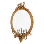 A VICTORIAN GILT GESSO OVAL GIRANDOLE HANGING WALL MIRROR with three acanthus scroll candle