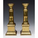 A PAIR OF 18TH CENTURY BRASS GUN BARREL CANDLESTICKS on square stepped plinths, 18.5cm high (2)