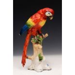 A SITZENDORF MODEL of a parrot sitting on a tree trunk, 28cm high