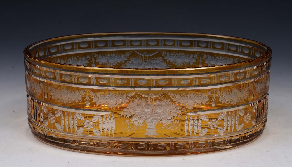 A BOHEMIAN AMBER GLASS OVAL BOWL with finely engraved basket of flowers and trailing floral swags