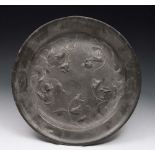 AN ARTS & CRAFTS PEWTER CIRCULAR CHARGER with raised scrolling tulip decoration, 38cm diameter