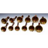 A GROUP OF TWELVE BRASS HAND BELLS ranging from 'C' to 'G' (an octave and a half) with leather