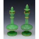 A PAIR OF BOHEMIAN APPLE GREEN GROUND BOTTLES of baluster form with stoppers and gilded line