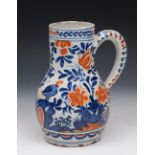 A DUTCH DELFT POTTERY BALUSTER JUG with iron red and cobalt blue bird and foliate decoration, 20.5cm