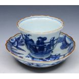 AN 18TH CENTURY JAPANESE BLUE AND WHITE PORCELAIN TEA BOWL AND SAUCER with figures in a garden