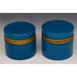 A PAIR OF POWDER BLUE OPALINE CYLINDRICAL GLASS JARS with hinged rising lids and gilt metal