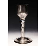 AN 18TH CENTURY WINE GLASS, the plain slightly tapered bowl on opaque twist stem, and slightly domed