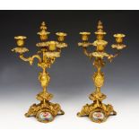 A PAIR OF FRENCH ORMOLU AND PORCELAIN MOUNTED FOUR LIGHT CANDELABRA decorated panels of flowers