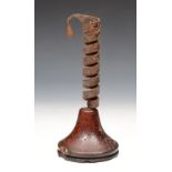 A 17TH CENTURY IRON AND WOODEN CANDLESTICK of wrythen form on a tapering base, 22cm high