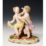 A 19TH CENTURY MEISSEN FIGURE GROUP of two putti, on gilt heightened base, 11.5cm high