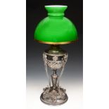 A VICTORIAN SILVER PLATED OIL LAMP of classical urn form with rams head mounts on circular base with