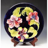 A MOORCROFT HIBISCUS PATTERN CIRCULAR PLATTER, signed and with impressed mark and paper label,