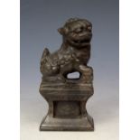 A CHINESE SOAP STONE DOG OF FO OR KYLIN seated on a plinth, 12cm high