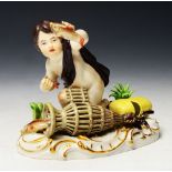 A 19TH CENTURY MEISSEN FIGURE of a young boy with fishing net and fish, a wicker creel with crayfish