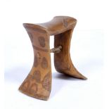 A UGANDA/KENYAN, KARAMAJONG LIGHT WOOD HEADREST of simple splay form carved with naive images of