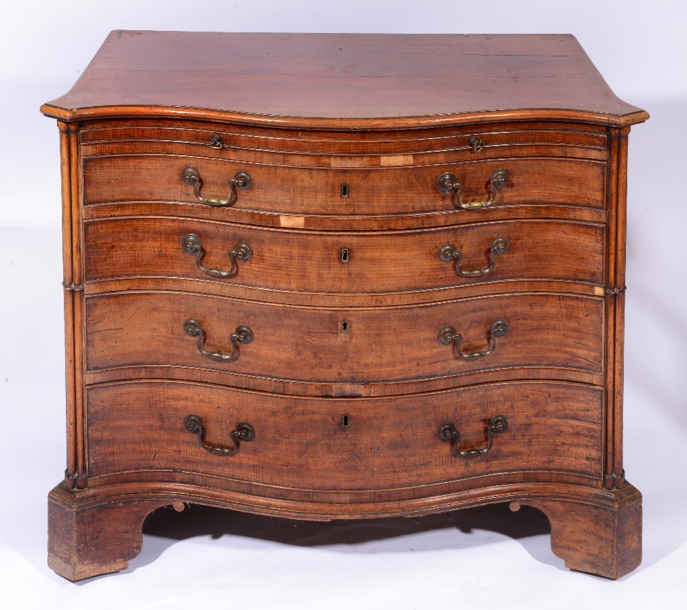 A GEORGE III MAHOGANY SERPENTINE CHEST of four long graduated drawers with brushing slide and