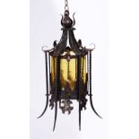 AN OLD WROUGHT IRON HANGING LANTERN with glass panels and ceiling boss, 40cm high