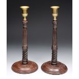 A PAIR OF GEORGIAN MAHOGANY CANDLESTICKS with brass drip pans, the columns of spirally fluted and