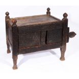 A 19TH CENTURY INDIAN PORTABLE CHEST with carved decoration, sliding door and tapering supports,