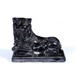 A 19TH CENTURY BRITISH TREACLE GLAZED MODEL of a seated lion on a rectangular plinth, 28cm long