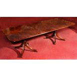 A REGENCY STYLE MAHOGANY DINING TABLE with twin turned column support, each on four fluted