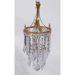A GILT METAL TWO TIER CHANDELIER, hung with two rows of faceted glass spear drops, a smaller gilt