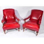 A PAIR OF RED LEATHER LIBRARY ARMCHAIRS, brass studded and on ring turned forelegs with castors,