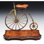 A MODEL of a 'Penny Farthing' originally a desk stand, now with ink pots missing on a serpentine