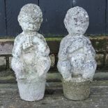 A pair of reconstituted stone figures of flute players,