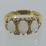 An 18 carat gold three stone opal and diamond ring,