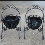 A pair of circular black painted iron garden planters,