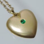 A Victorian 15 carat gold heart shaped locket, set with an emerald,