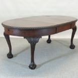 An early 20th century mahogany wind out extending dining table, on claw and ball feet,