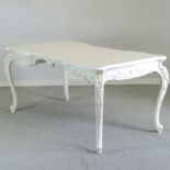 A French style white painted table, on cabriole legs,