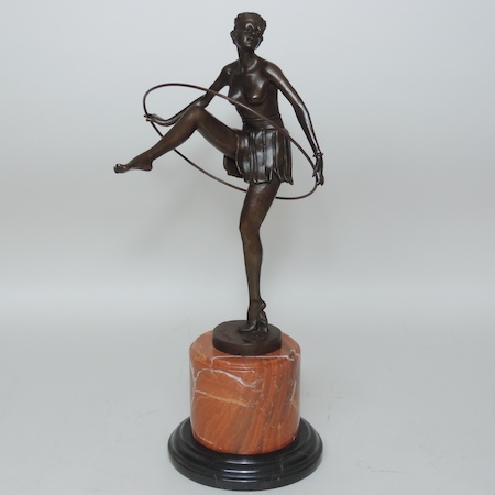 An Art Deco style bronze figure of a dancer, holding a hoop,