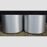 A set of four aluminium coloured circular planters,