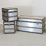 A set of three contemporary aluminium and wooden bound trunks, largest,