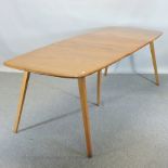 An Ercol light elm extending dining table, with two additional leaves,