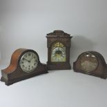 An early 20th century oak carved mantel clock, with a brass dial, striking on a gong,